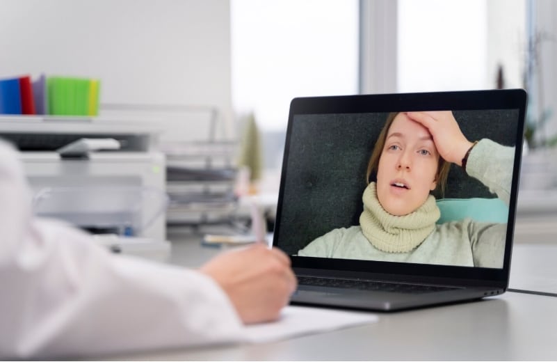 Doctor teleconsulting with patient via laptop for medical evaluation and FMLA certification support