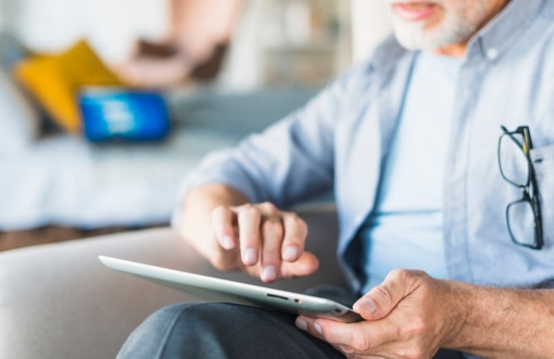 Elderly person using a tablet to complete FMLA certification online for workplace leave application