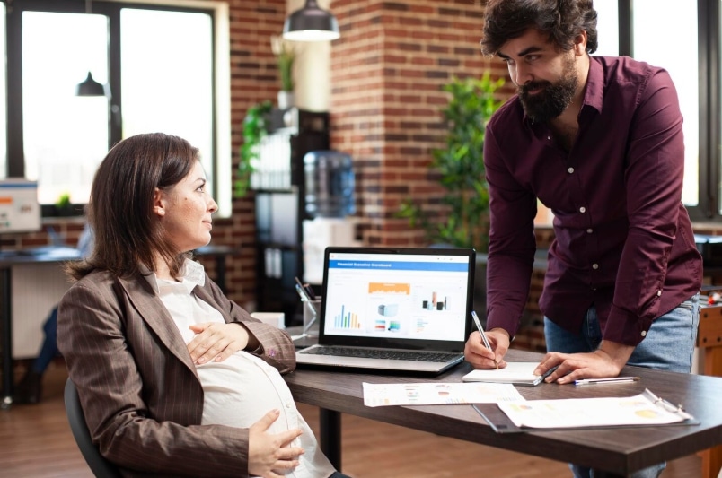 Employee submitting FMLA pregnancy paperwork to HR for medical leave processing and approval