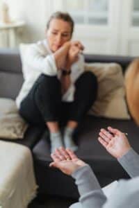a woman sitting on the couch and crying.