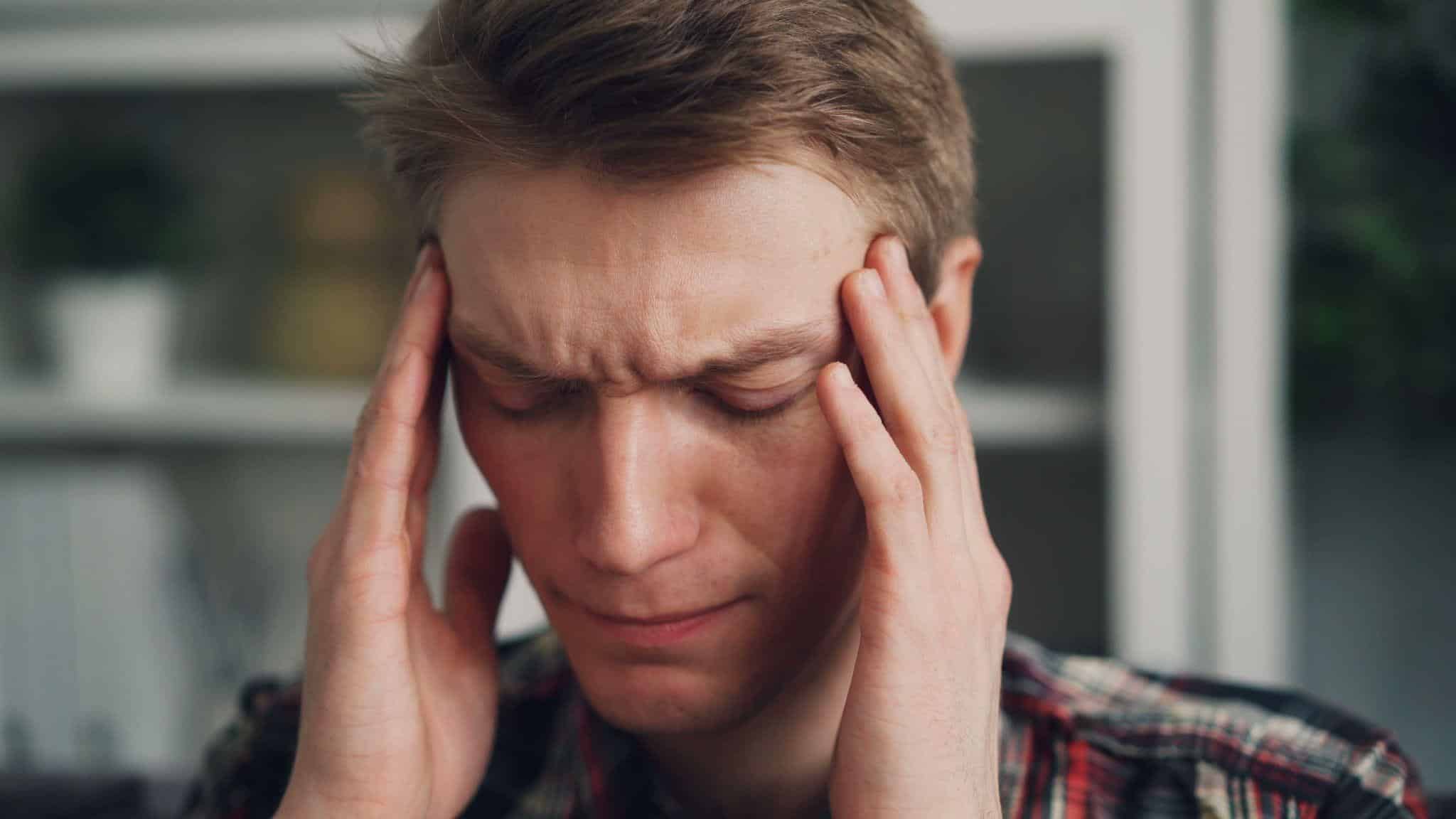 a person holding their head due to pain