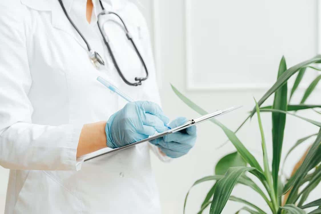 Doctor signing FMLA certification paperwork for an employee requesting medical leave