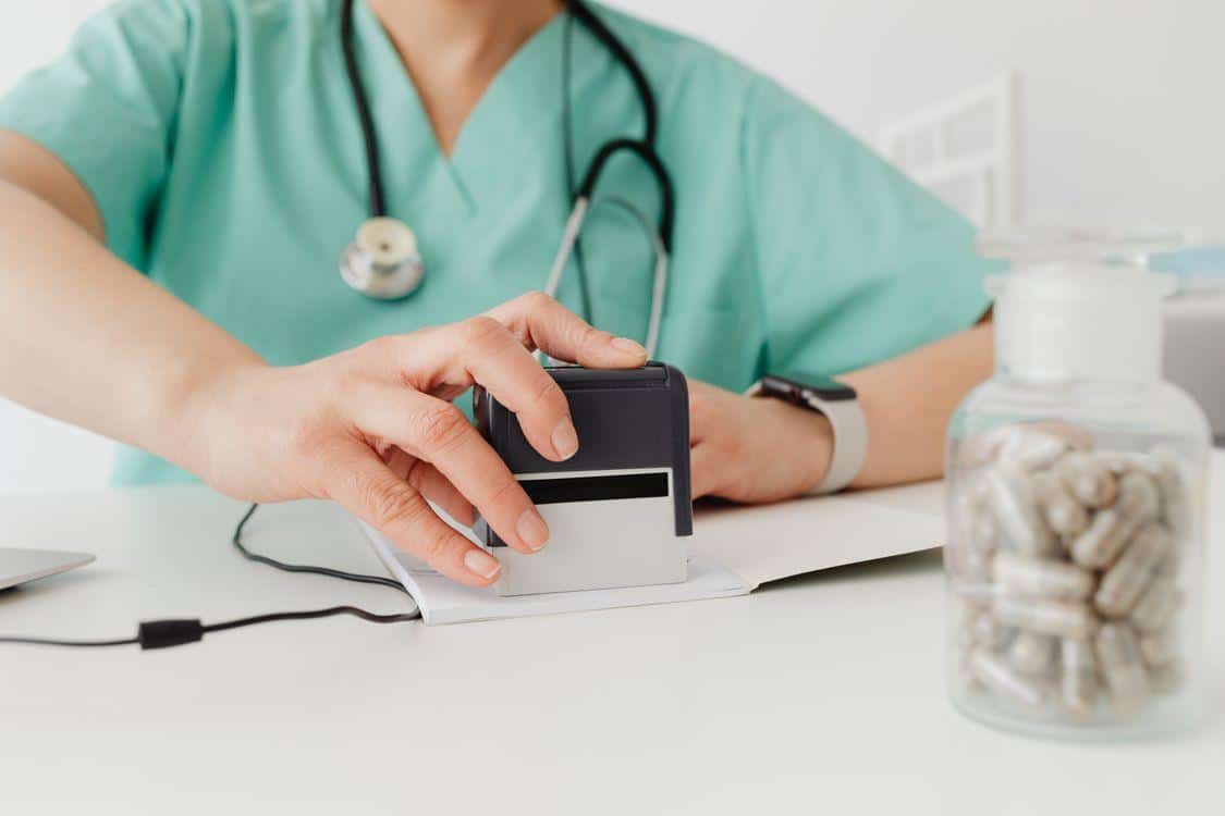 Doctor stamping a medical document as part of the FMLA certification process