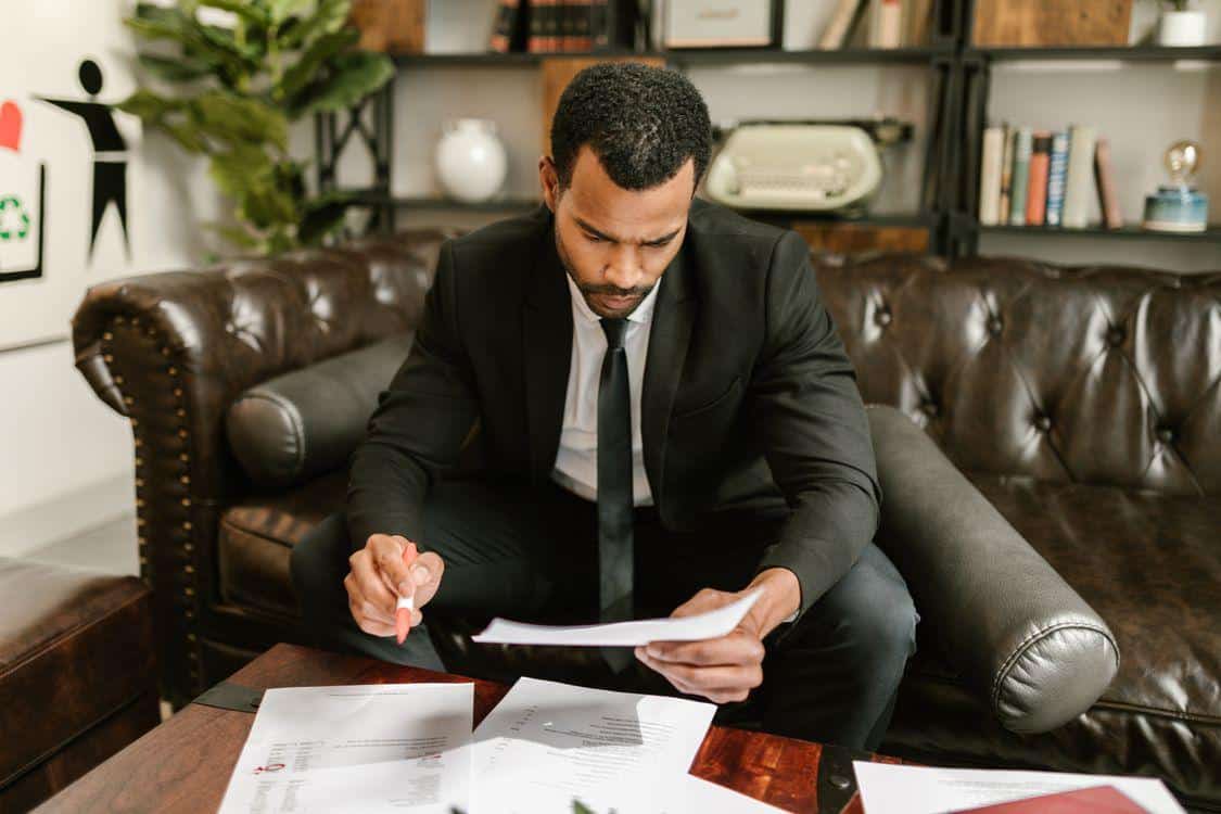 Man sitting on leather sofa reviewing important medical documents for FMLA