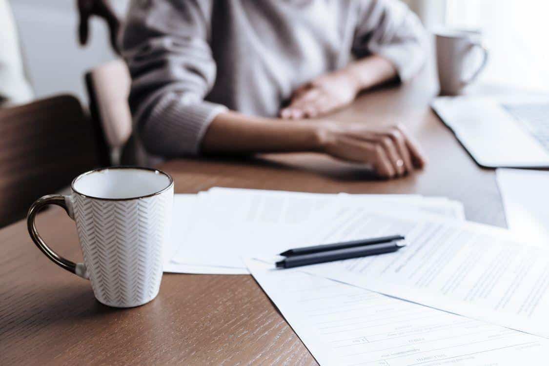 Mug and papers on table representing workspace for online medical paperwork processing