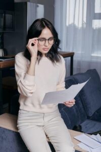 Woman wearing glasses examining FMLA certification paperwork at her desk