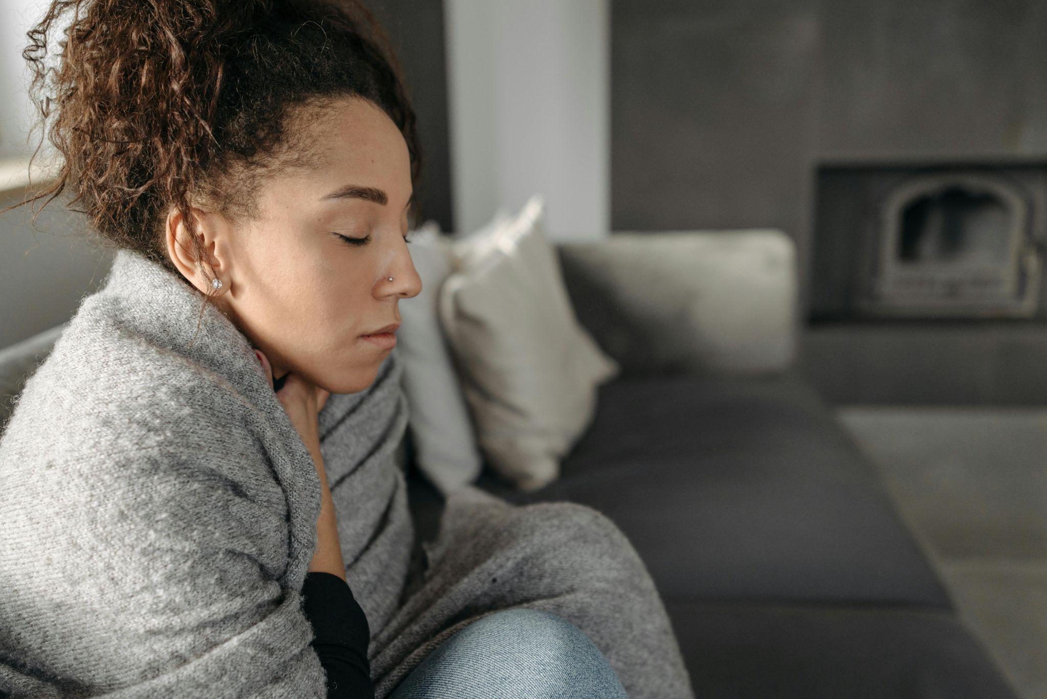 Woman resting on sofa with eyes closed reflecting need for rest and medical leave