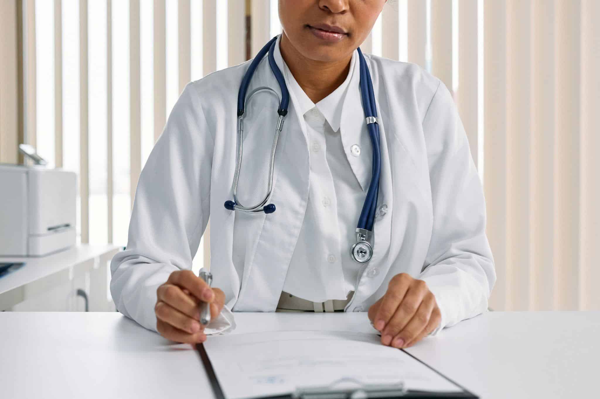 a doctor signing on a note