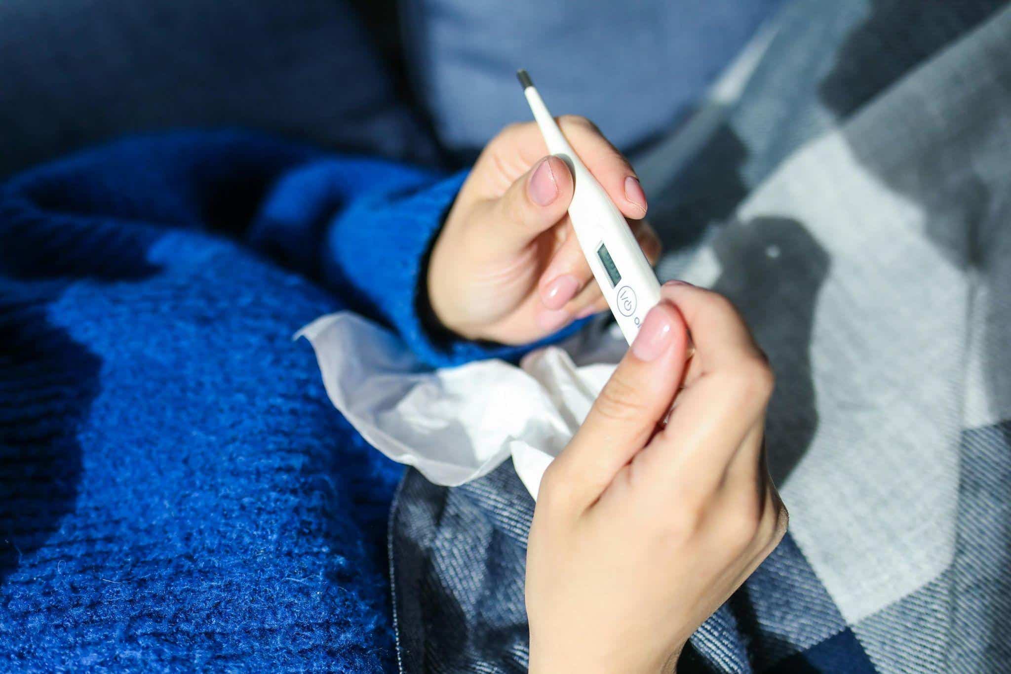 a sick person checking their temperature on leave