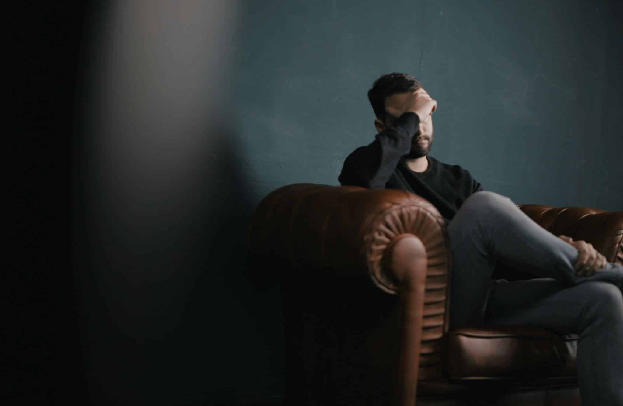a person holding their head with their hand