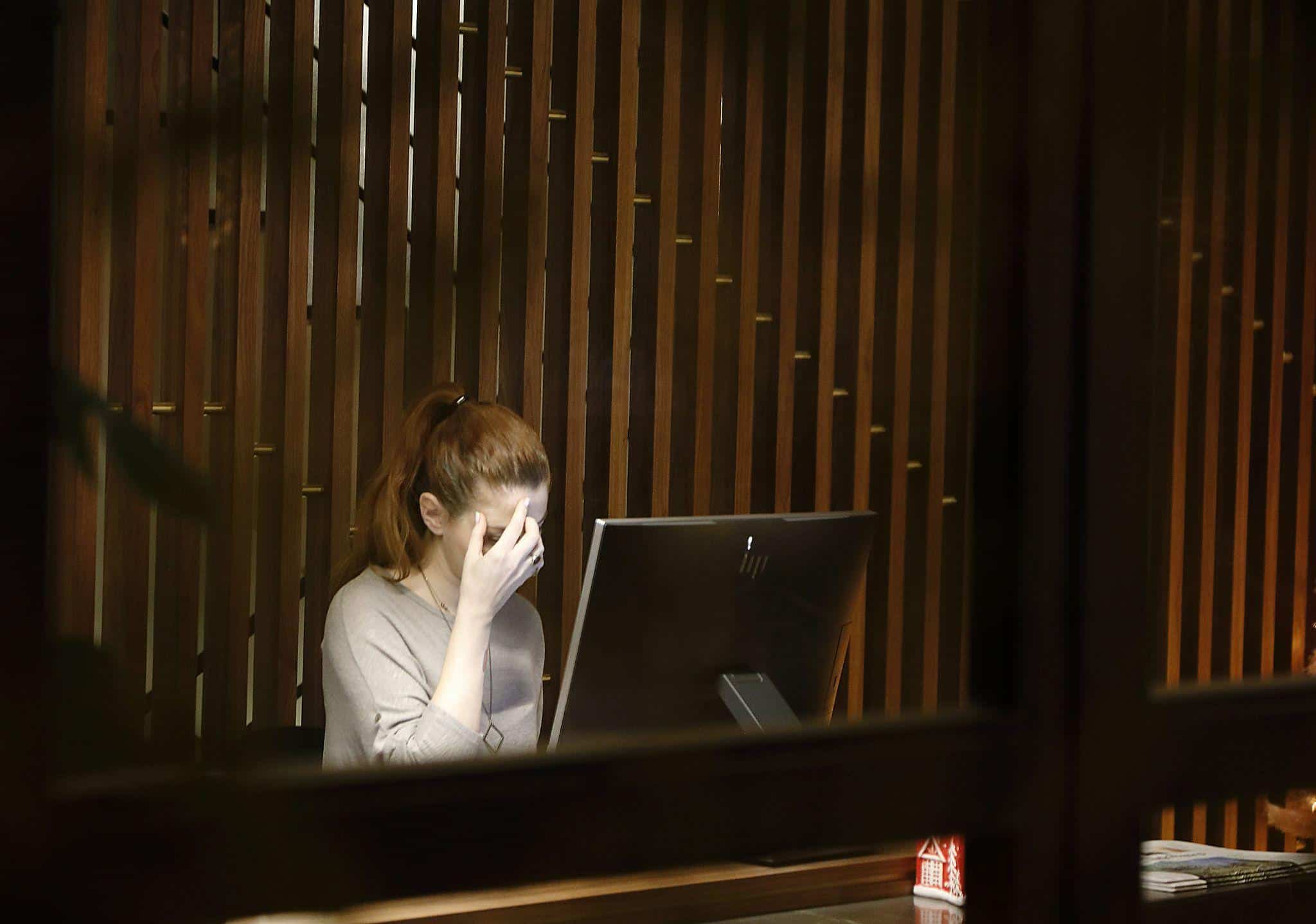 a woman suffering from a migraine at an office