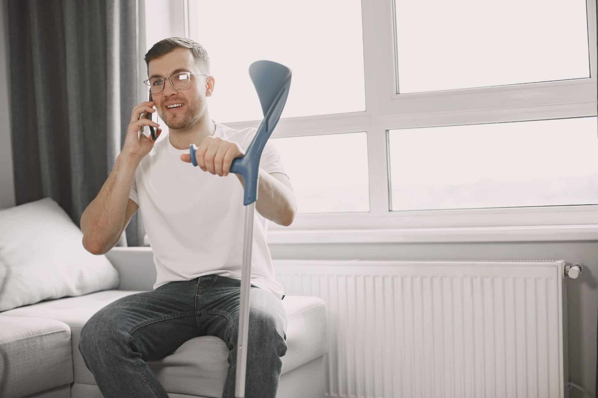 a person sitting supported by a crutch